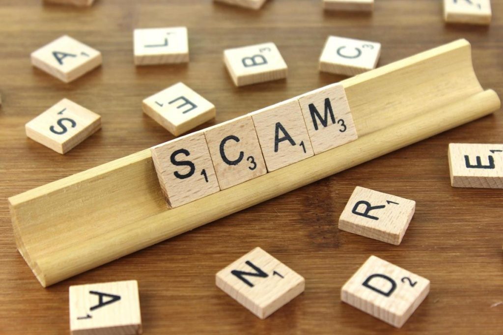 Letter tiles spelling out "scam"